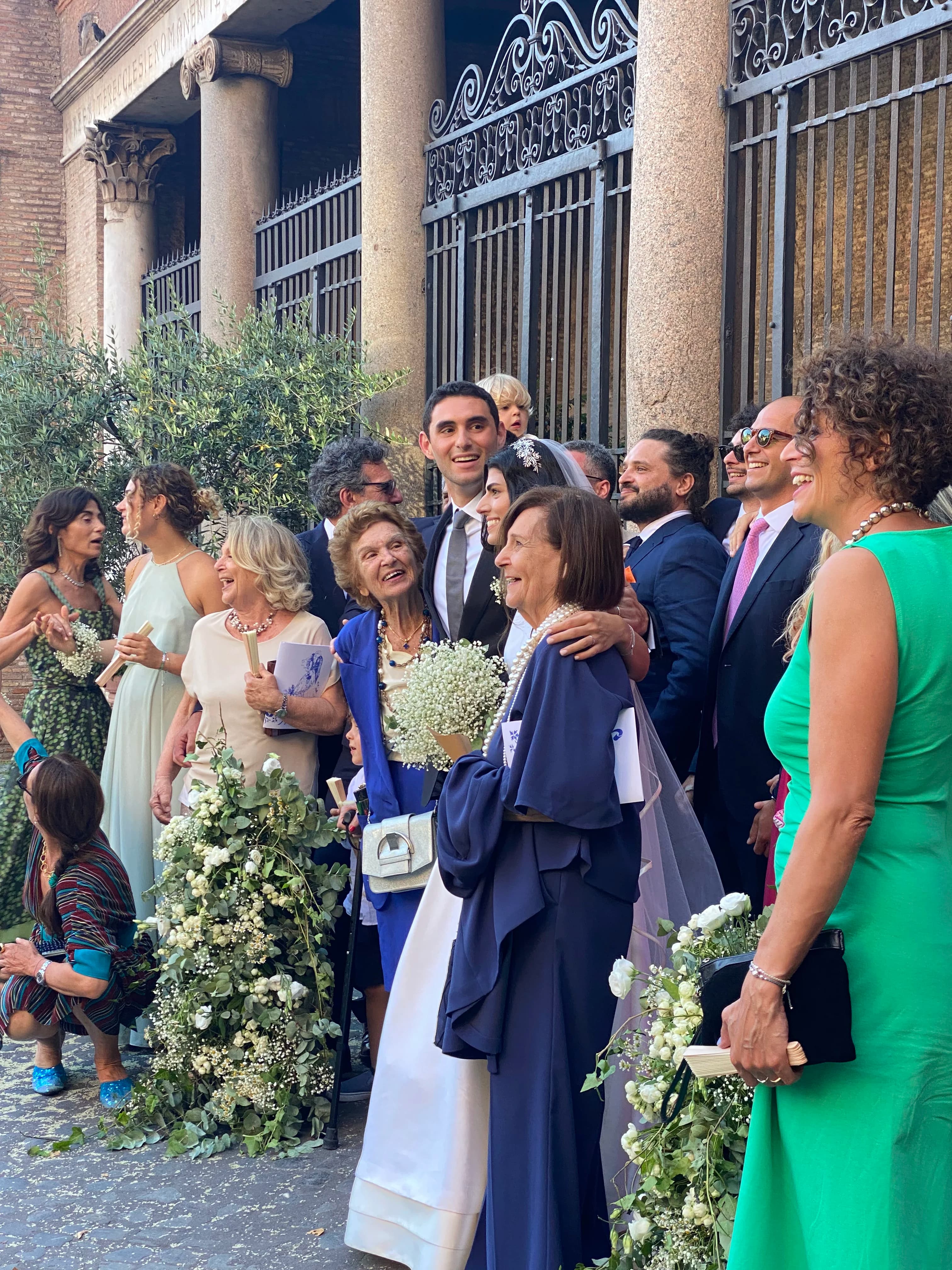 Sposa e invitati con bouquet e addobbi floreali bianchi durante un matrimonio